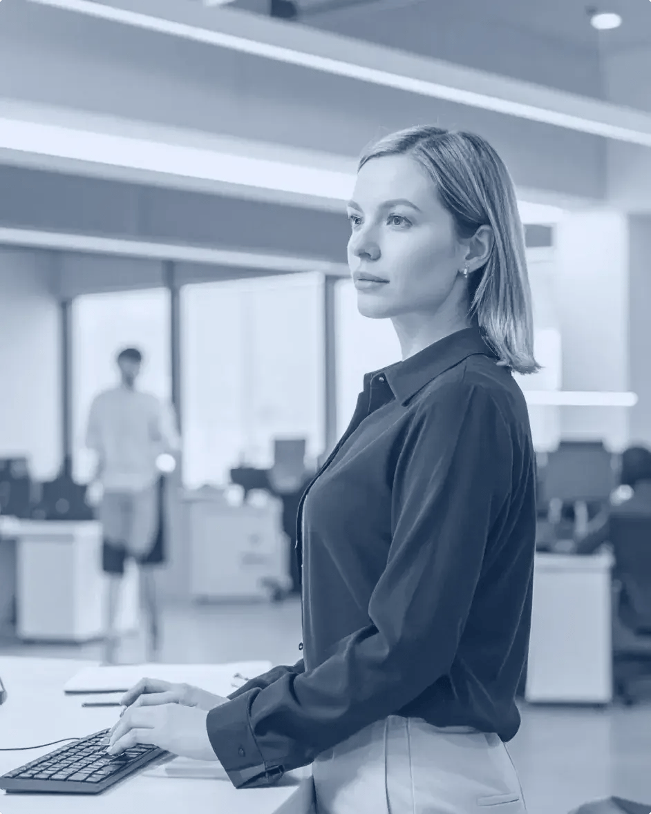 une femme au travail debout devant un écran d'ordinateur