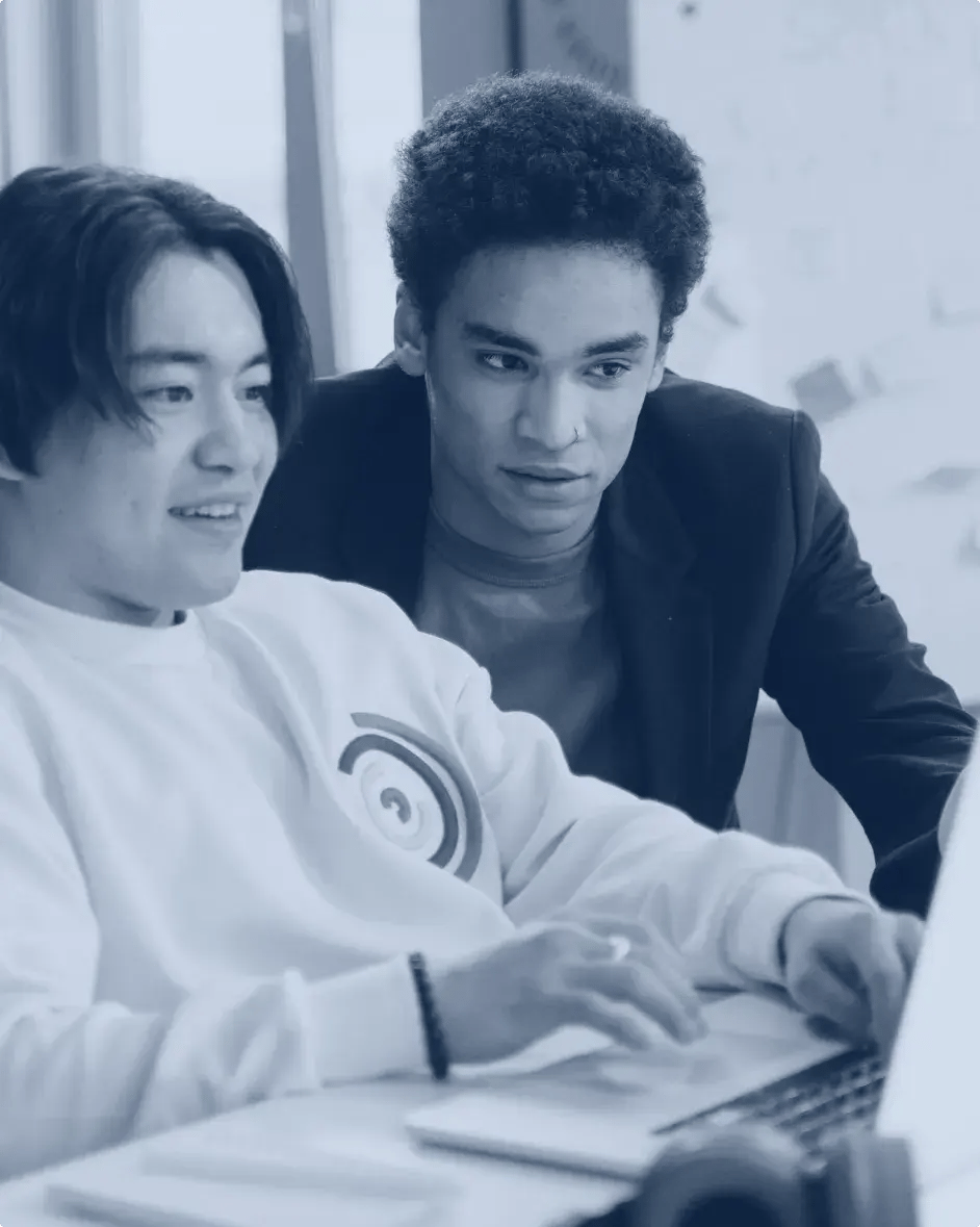 deux hommes qui regardent le même écran d'ordinateur portable